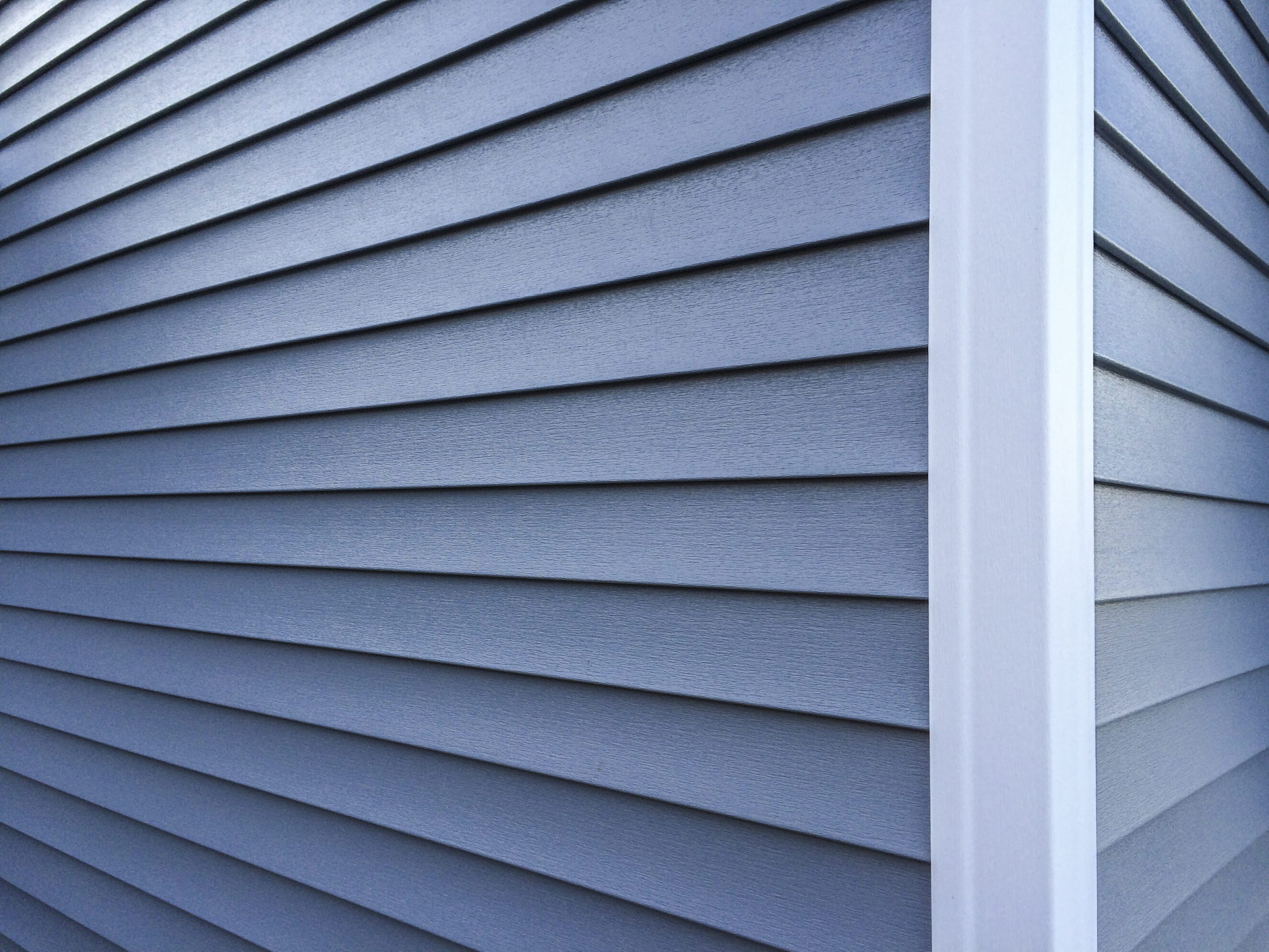 Blue Vinyl Siding Close-up of durable, low-maintenance blue siding panels on a home exterior corner, highlighting quality siding solutions for enhanced curb appeal and weather protection.